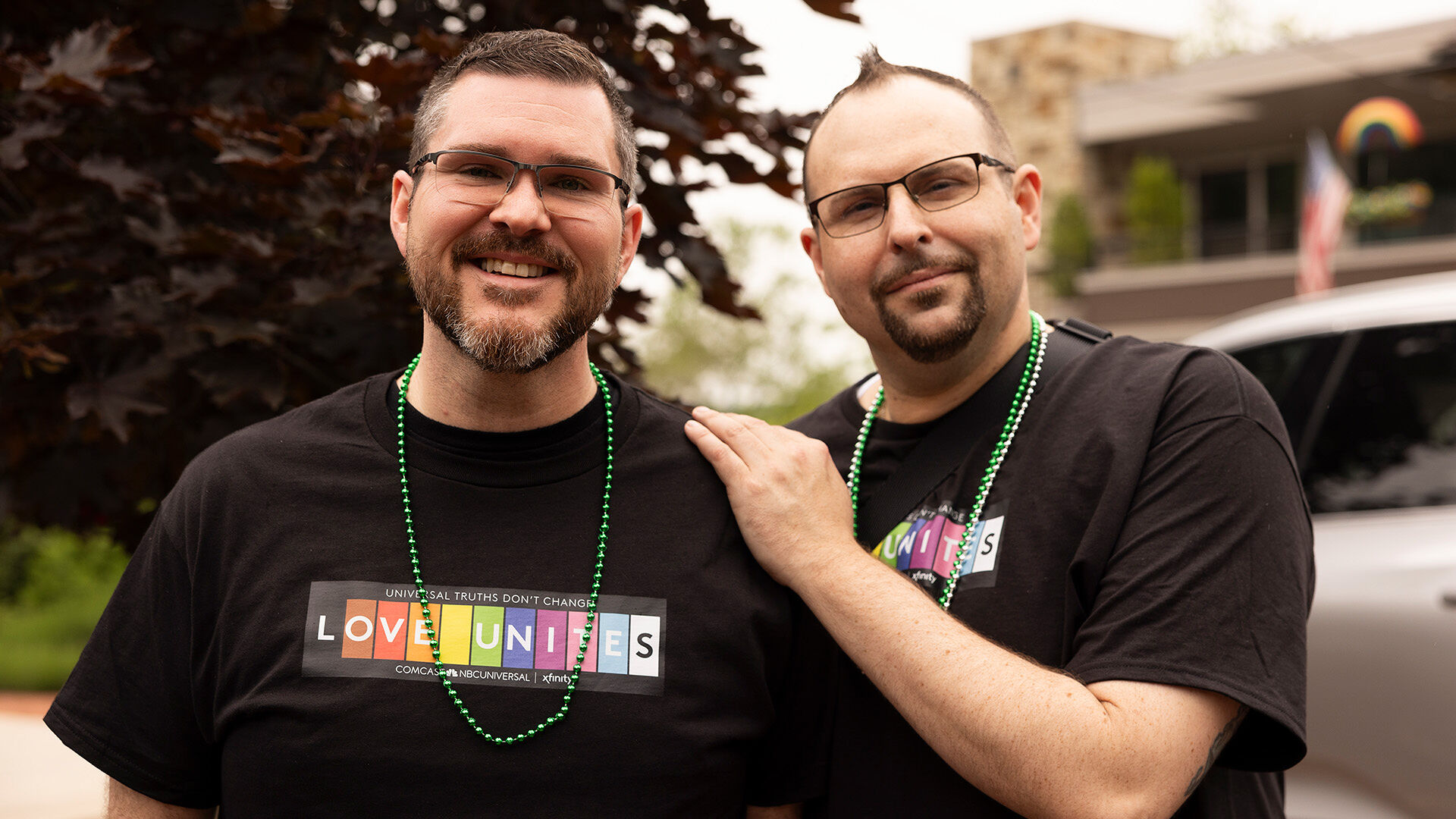 Pride parade participants wearing 'Love Unites' T-shirts.