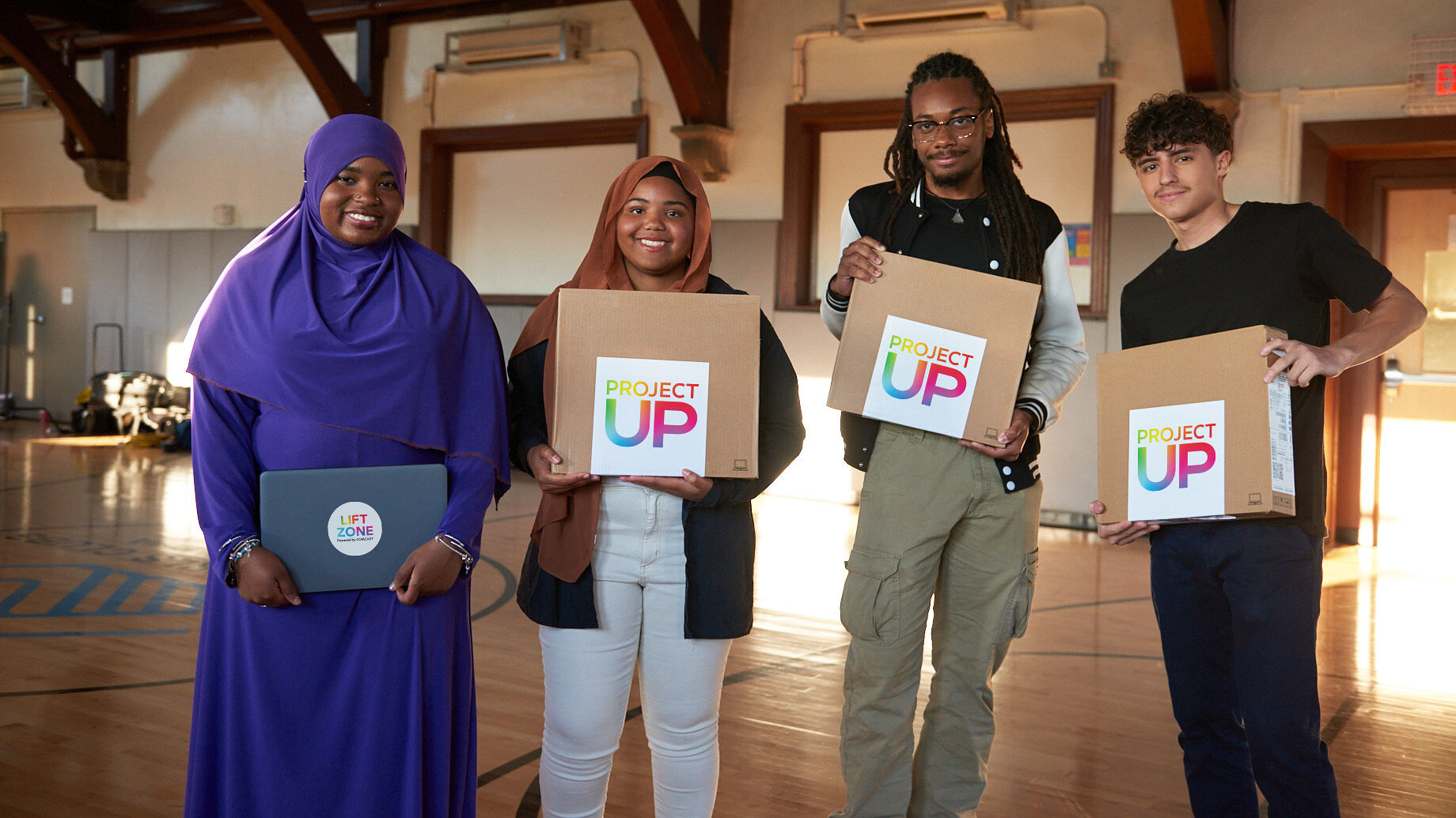 A group of students holding Project UP laptops.